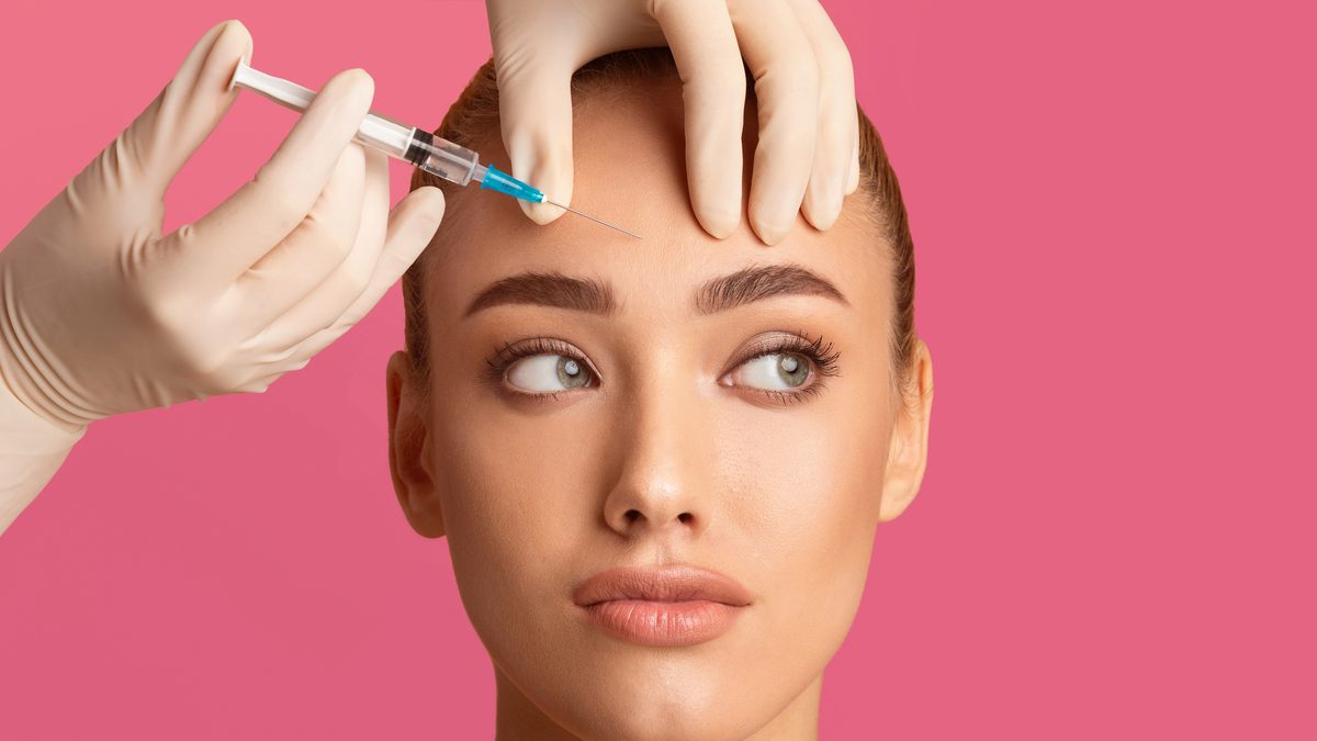 Woman receiving botox injection in forehead — Cosmo Clinic Lisbon